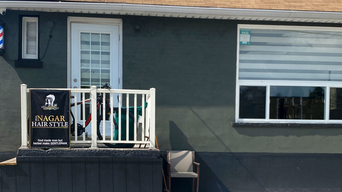 Nagar Hairstyle storefront and barber at work